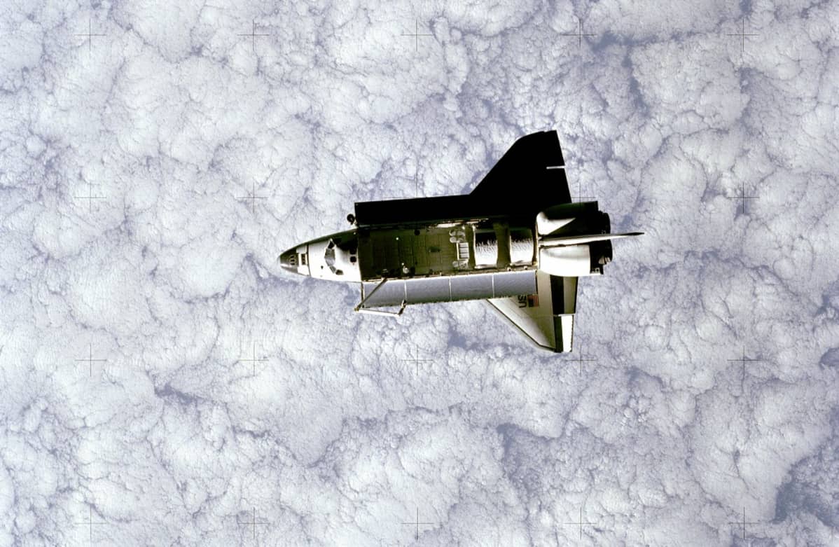 Avaruussukkula Challenger satelliitin kuvaamana . Alla Maan paksu pilviverho.