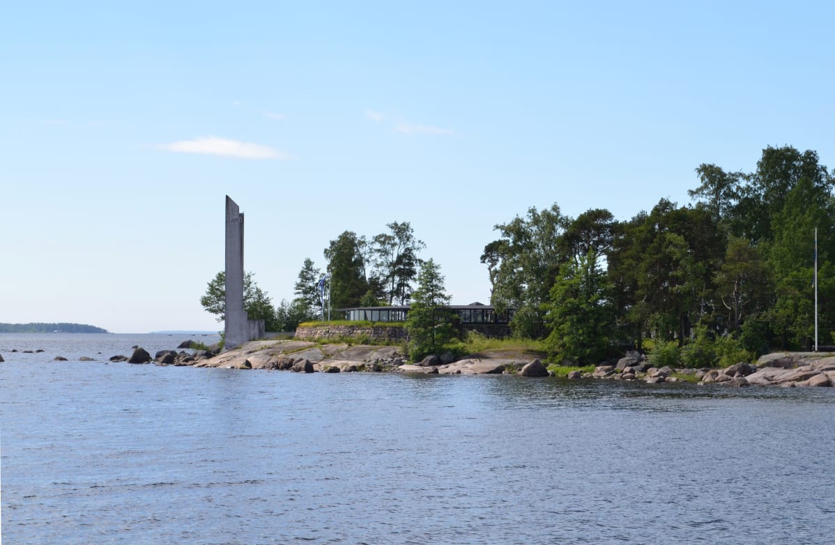 Varissaaren rantaa, jossa ravintolarakennus ja muistomerkki.