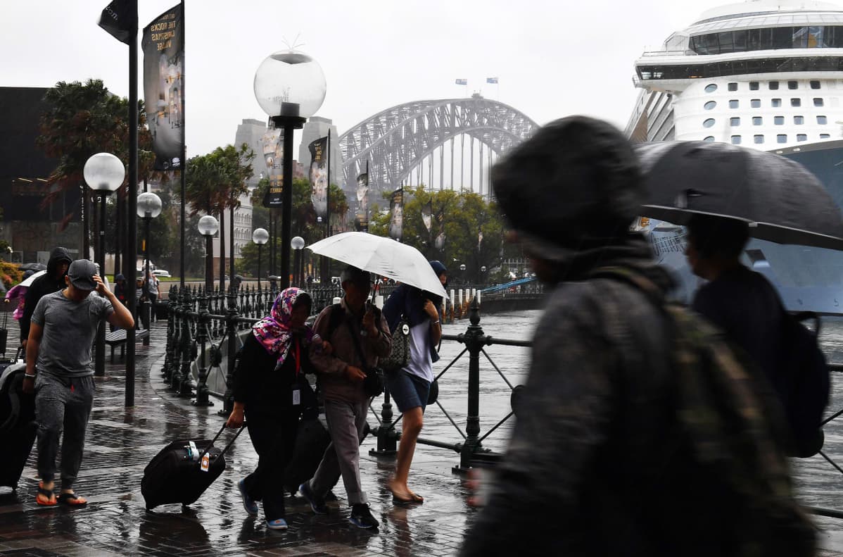 Jalankulkijoita sateessa Sydneyssä.