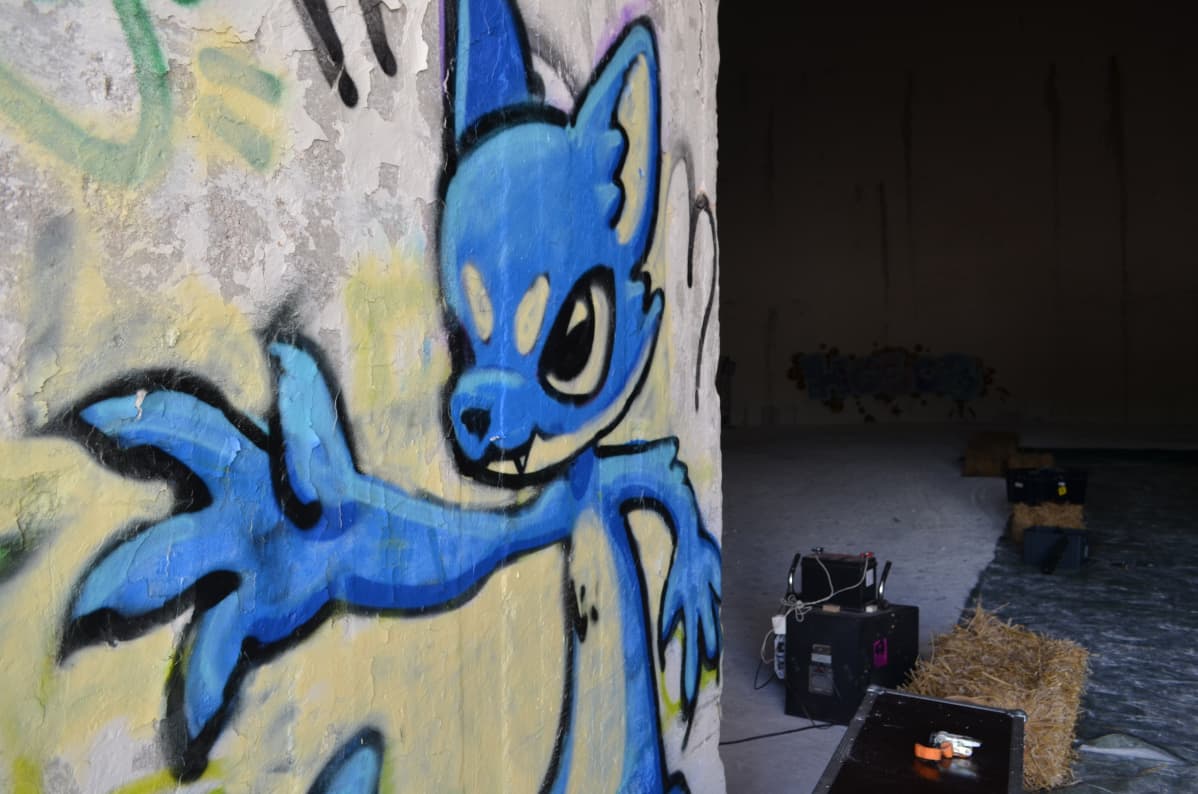 Graffitihahmo kutsuu tummanpuhuvaan siiloon, jossa järjestetään Joutomaa Fest Kotkassa.