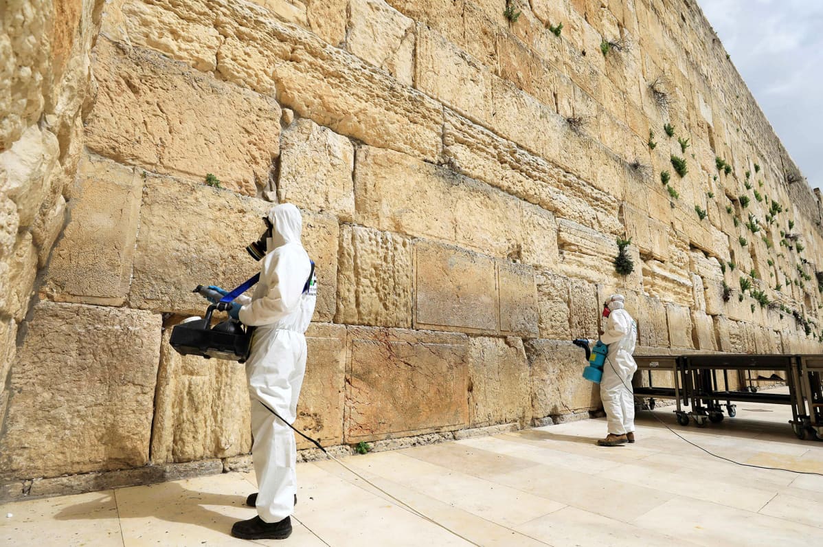 Työntekijät desinfioivat Itkumuuria Jerusalemissa.