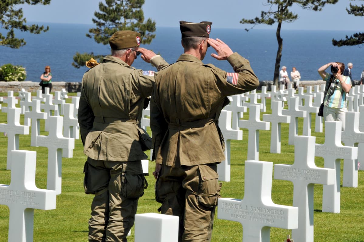 Amerikanska soldater står på en gravgård för offren på Normandie.