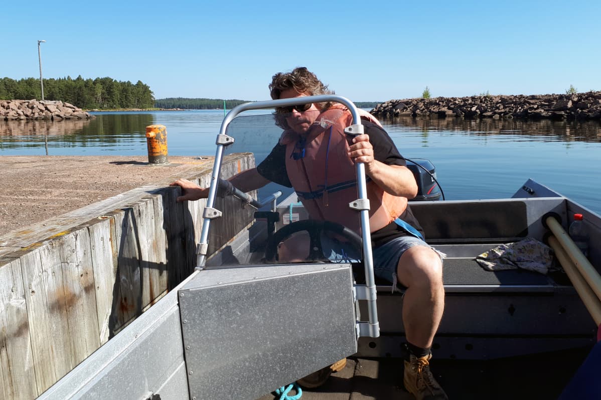 Veli Vartiala rantautuu veneellä saareen