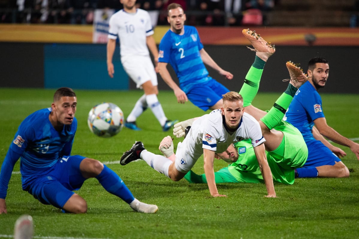 Suomen Jasse Tuominen kamppailee pallosta Kreikan pelaajia vastaan.