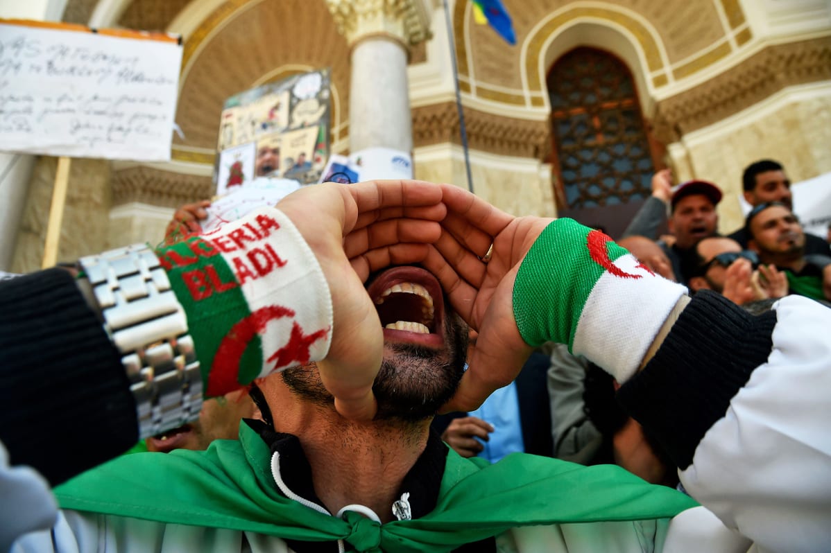 Algerialainenmies huusi iskulauseita Algierissa vapunpäivän mielenosoituksessa.