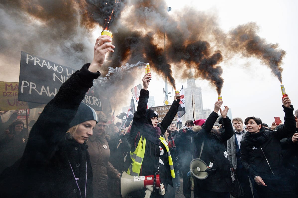 Mielenosoittajat protestoivat Varsovassa naisten aborttioikeuden tiukennuksia vastaan mustalla savulla ja vaatetuksella.