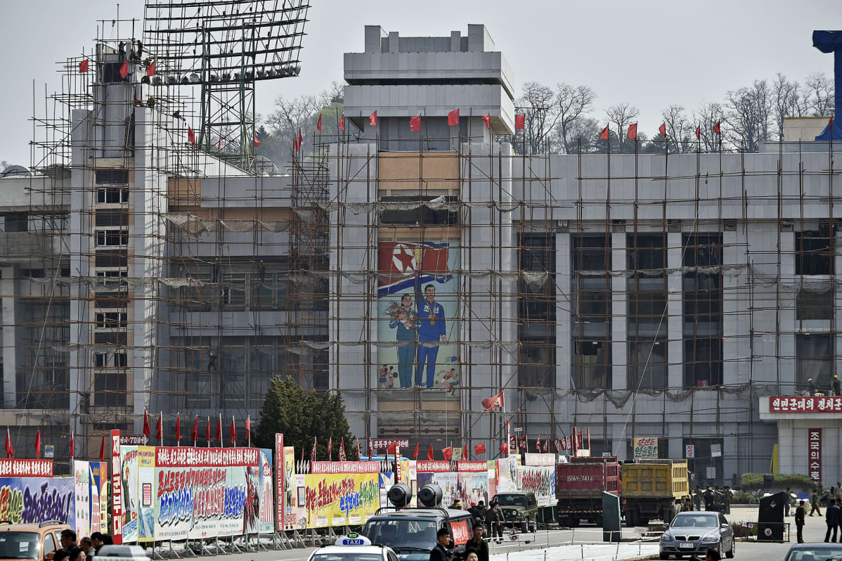 Propagandajulisteita rakenteille olevan stadionin edustalla.