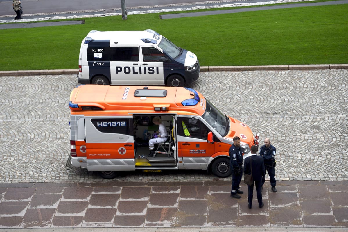 Poliiseja ja ambulanssi eduskunnan edustalla Helsingissä perjantaina.