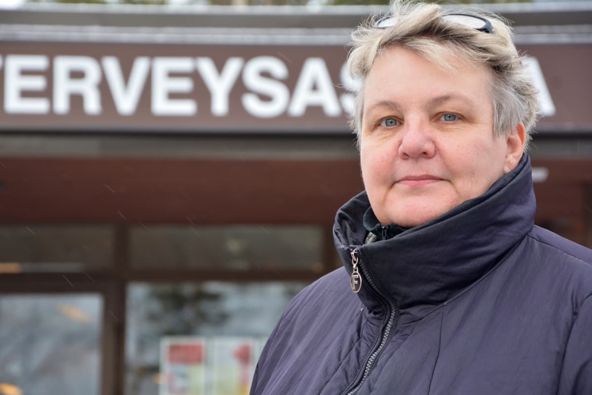 Nainen katsoo kameraan Nousiaisten terveysaseman edessä.