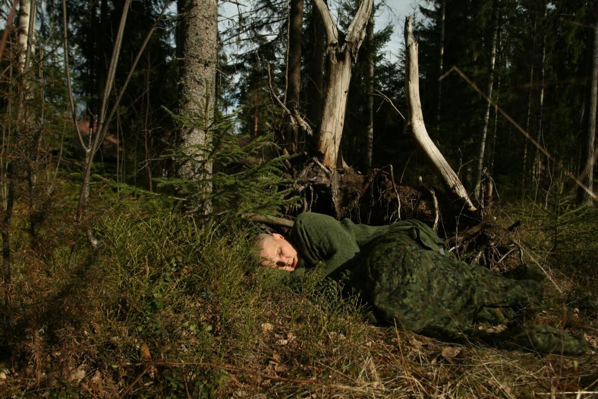 Anneli Jauhiainen makaa metsässä