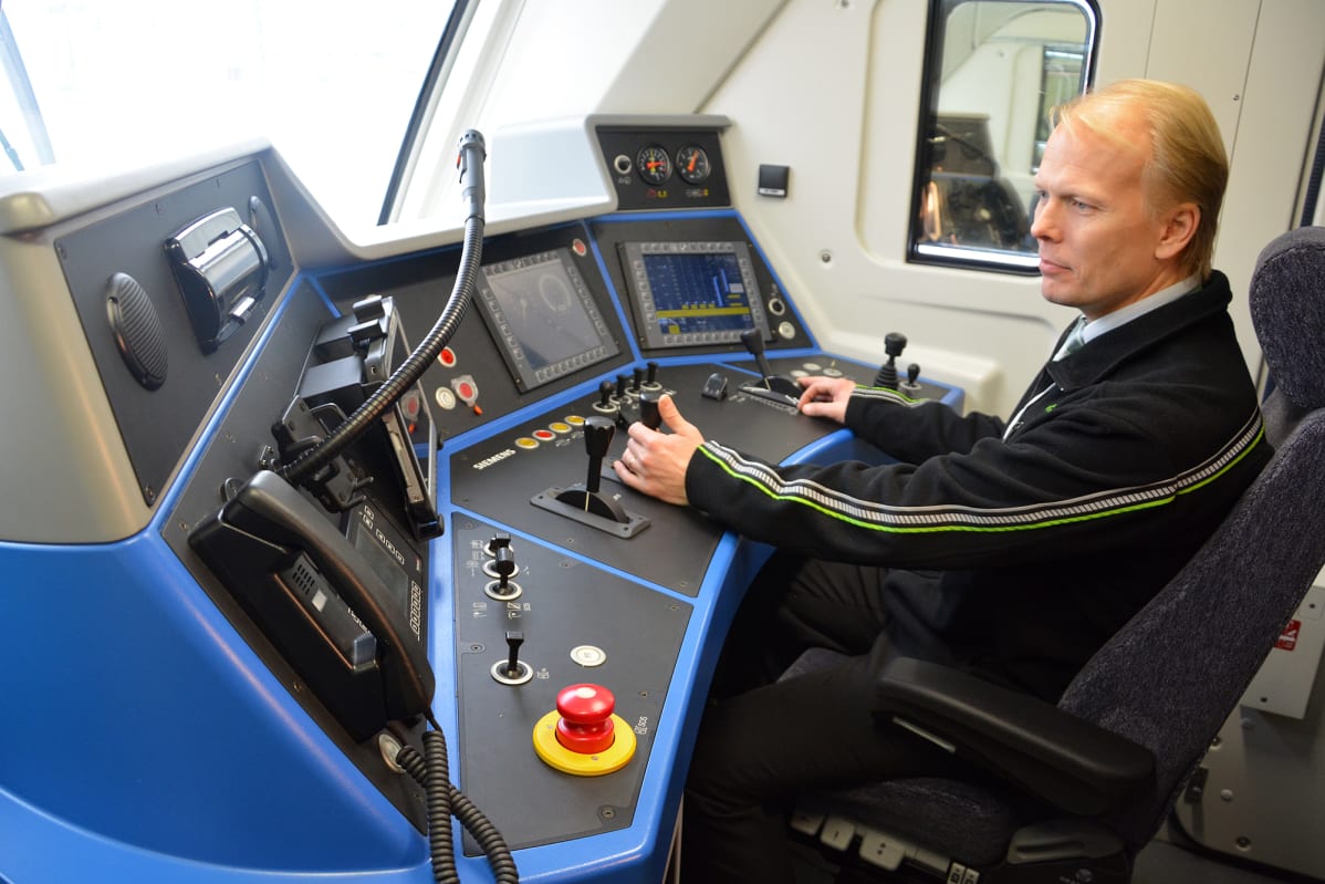 Veturinkuljettaja Samuli Juntto esittelee Vectron-hybridiveturin ohjaamoa.