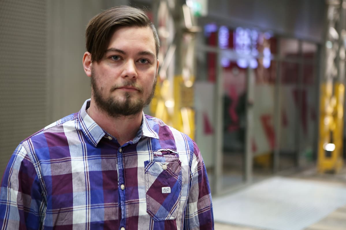 Mies poseeraa kameralle.