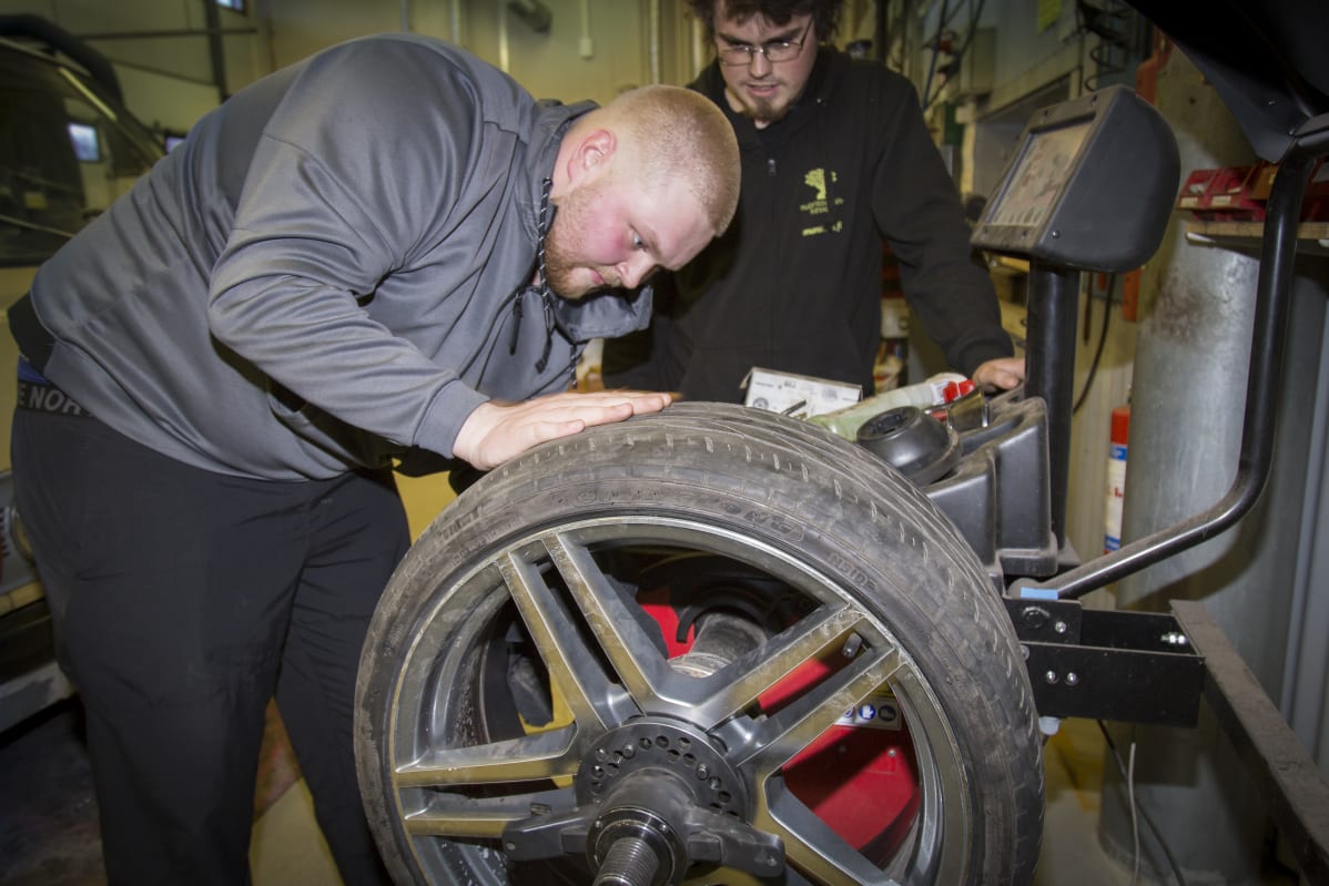 Konsta Vettenranta tasapainoittaa rengasta, Aivo Päri katselee.