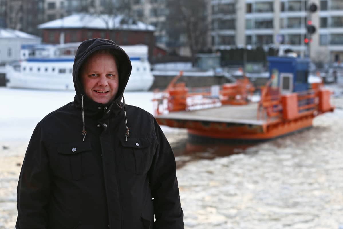 Mies seisoo Turun Aurajoen rannassa Föri-laiturin lähellä.