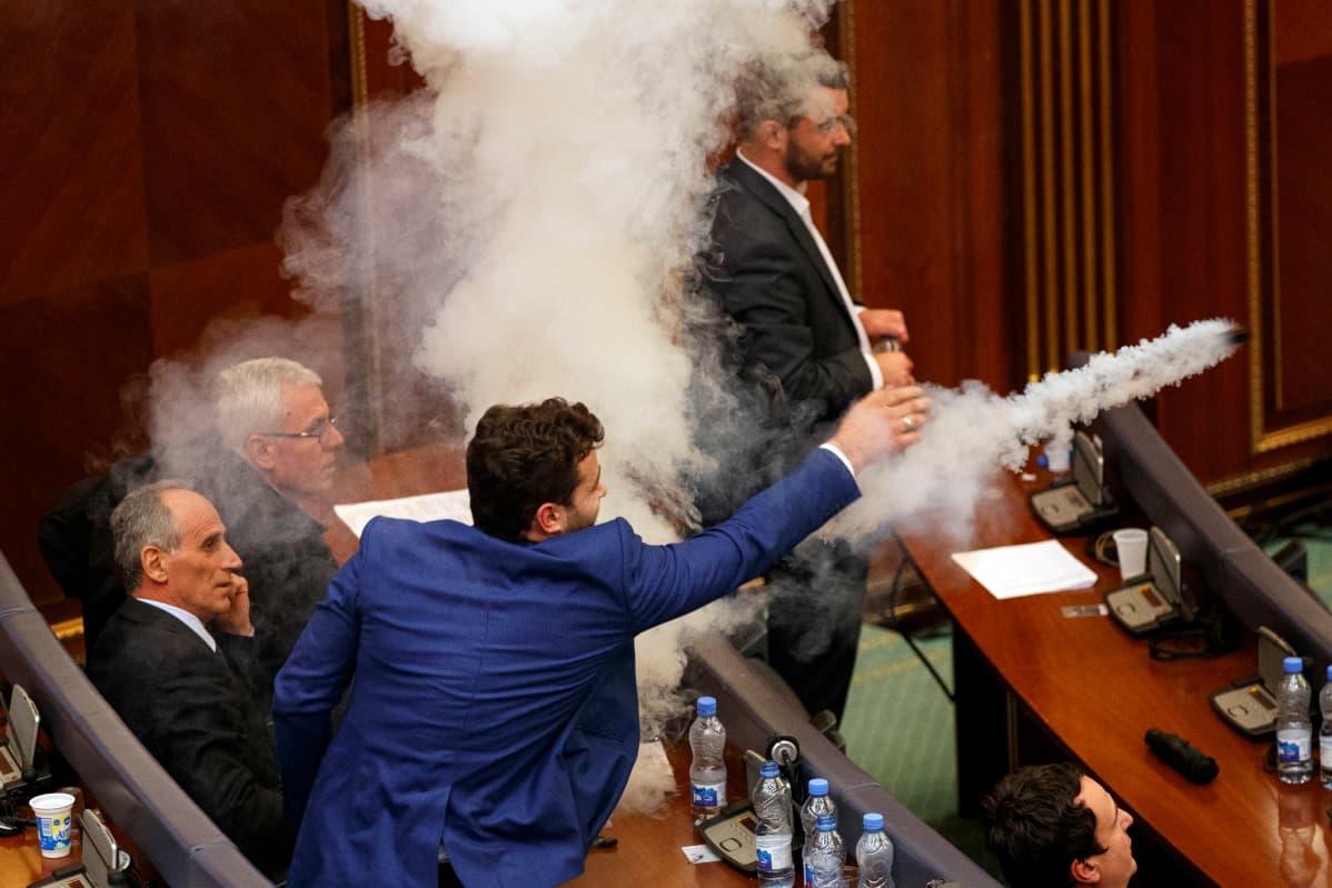 Kansallismielinen kansanedustaja heittää kyynelkaasupanoksen Kosovon parlamentin istunnossa maaliskuussa 2018. Parlamentti hyväksyi Montenegron kanssa neuvotellun rajasopimuksen.