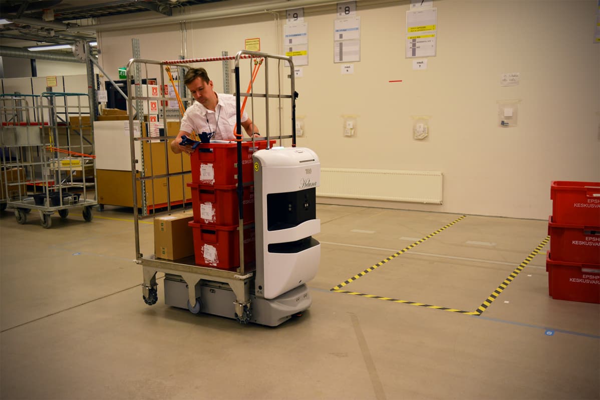 Seinäjoen keskussairaalan logistiikkapäällikkö Ville Ruuskanen tarkistaa robotin kuljettamaa lähetystä.