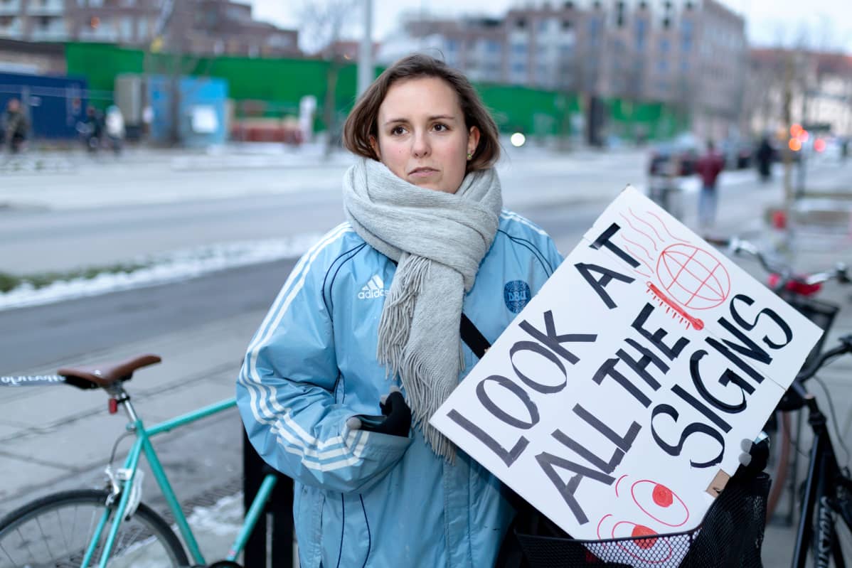 Sussi Lillelund mielenosoituskyltti kädessään