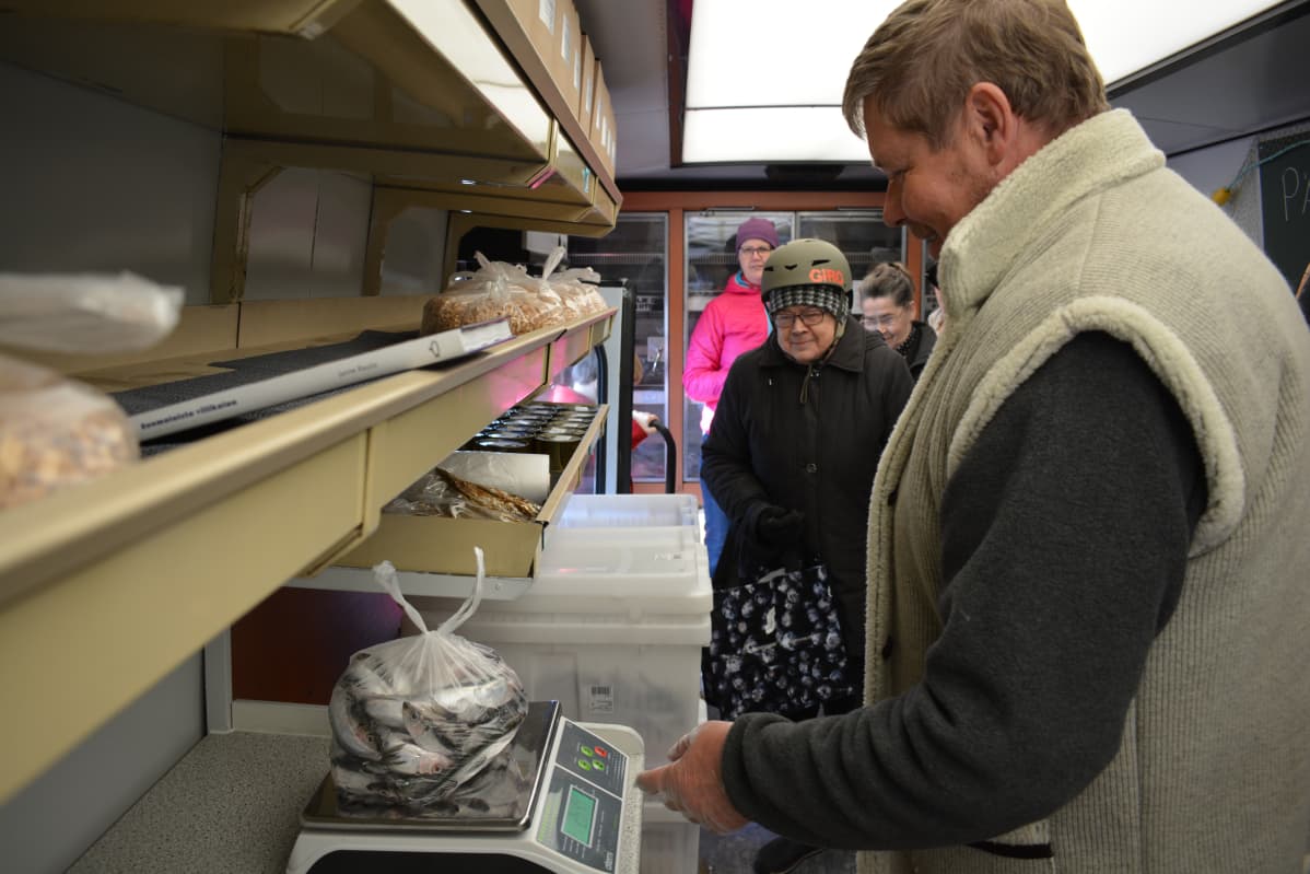 Kalastaja Jukka Toivonen punnitsee suosittuja silakoita kauppa-autossa.