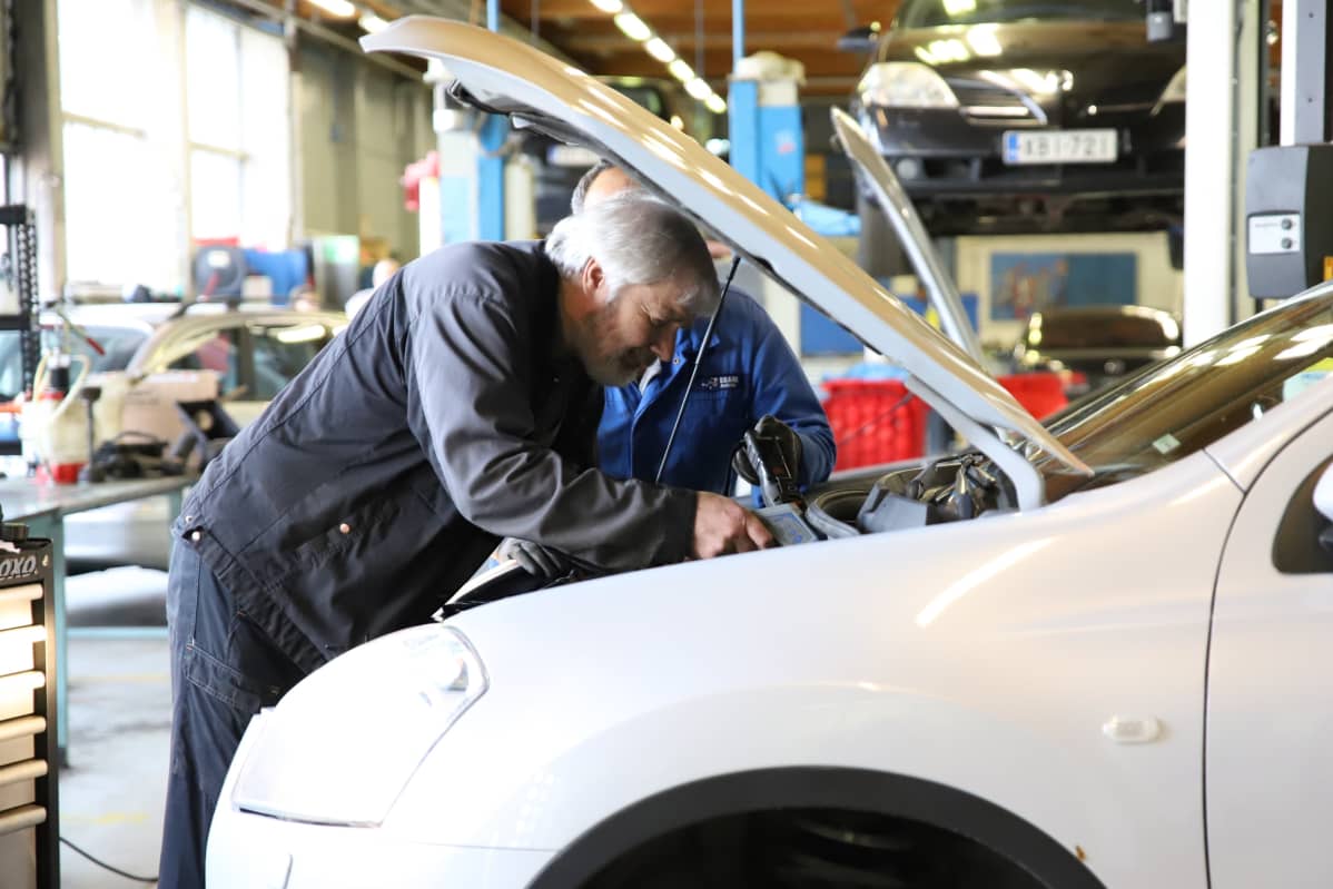 Autoalan opettaja Petri Sällilä tutkii autoa.