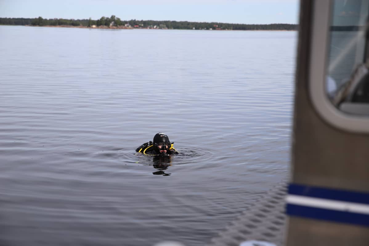Sinikka Kärkkäinen vedessä aloittamassa sukellusta.