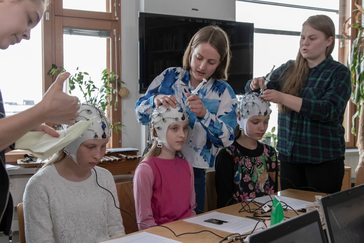 Viidesluokkalaiset Lumi Markkanen (vasemmalla), Taika Granroth ja Martta Murdvee osallistuvat Helsingin yliopiston tutkimukseen, jossa mitataan lasten kykyä keskittyä koulutehtäviin häiriöäänien keskellä.