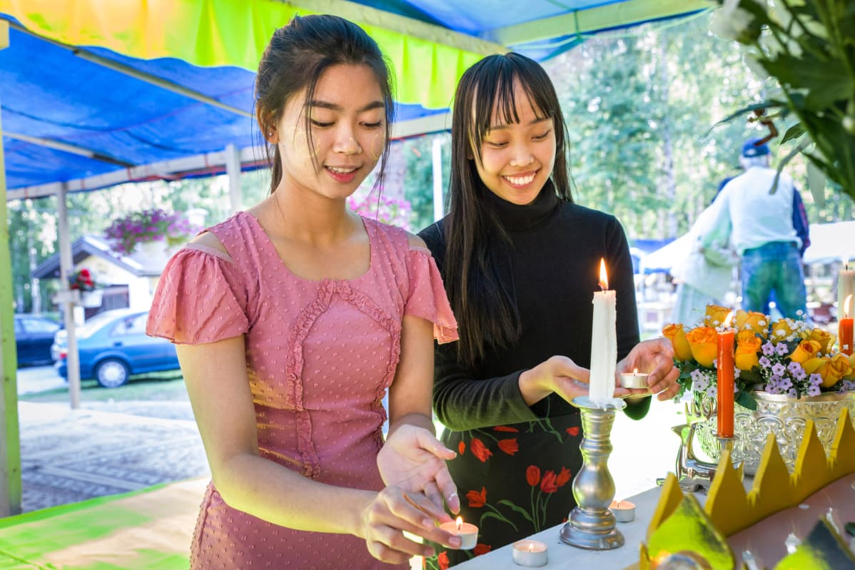 Wine Wine ja Chu Chu Kyaw sytyttävät kynttilöitä
