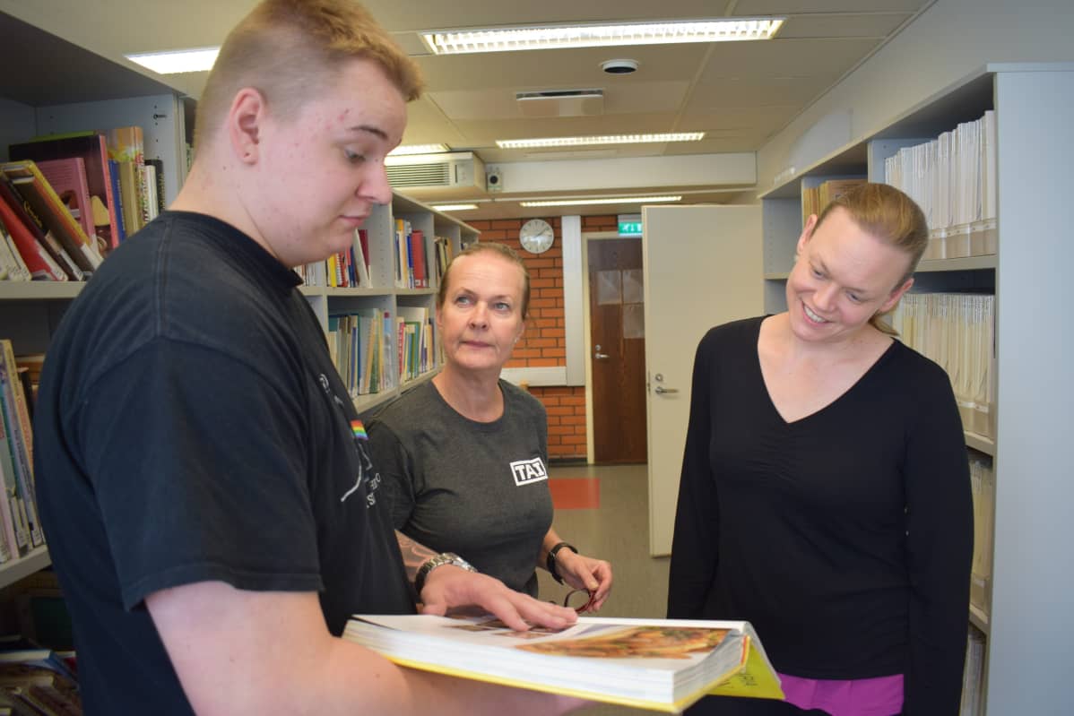 Kokkiopiskelija esittelee ruokakirjaa naisille