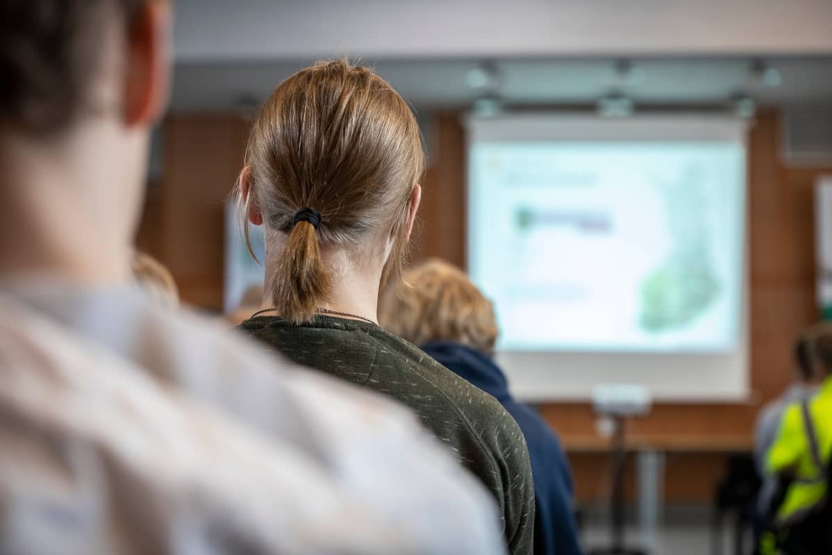 Mies kuuntelee kutsuntojen tilaisuudessa ohjeita Kuopiossa.