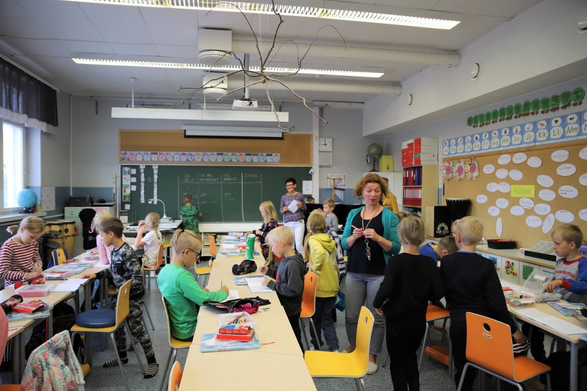 Aapiskujan koulun kakkosluokkalaiset opiskelevat kahden opettajan opastuksella. Oikealla Henna Hernesniemi ja luokan edessä Heini Ylisuutari.