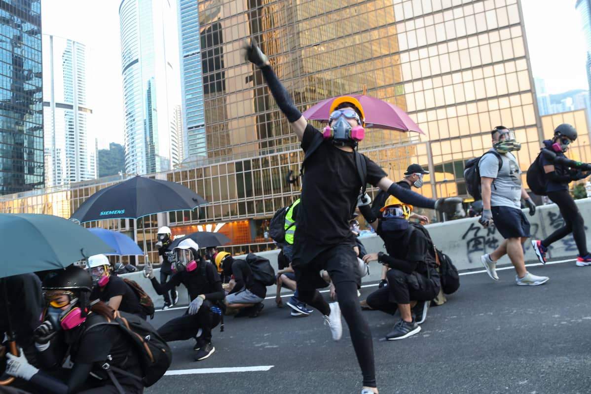 Mielenosoittajia kaasunaamareissa Hongkongin hallintokeskuksella