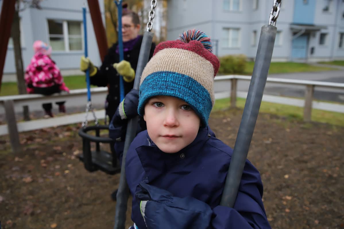 Pieni poika keinumassa kotipihan keinussa.