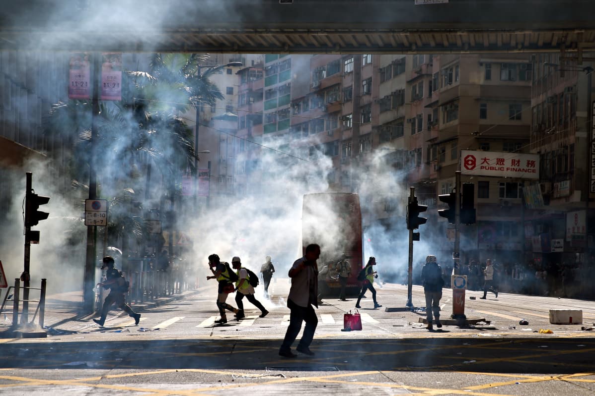 Kyynelkaasua leijuu ilmassa Hongkongin keskustassa lähellä paikkaa, jossa poliisimies ampui pistoolilla mielenosoittajaa.