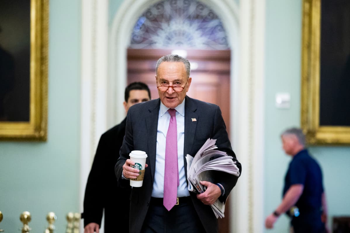 Demokraattisenaattori Chuck Schumer kulkee kahvimukin kanssa