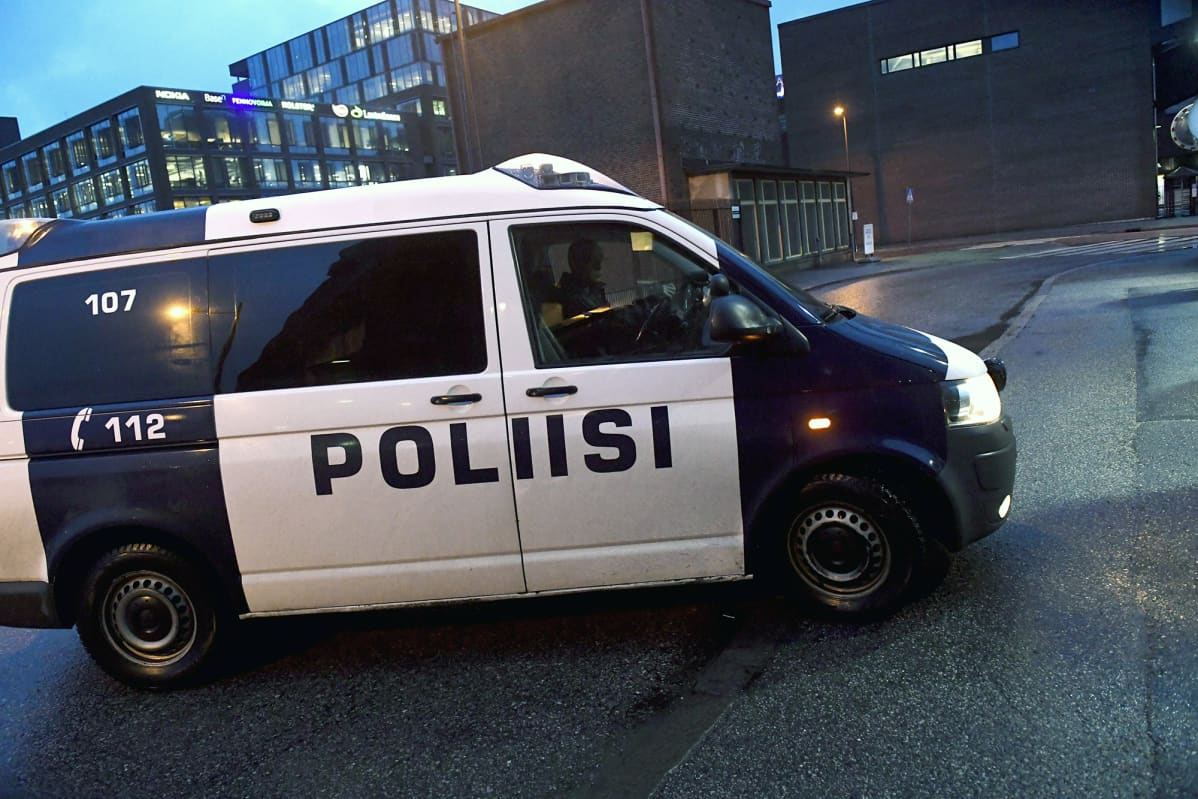 Poliisiauto ajaa oikeustalon portille Helsingissä.