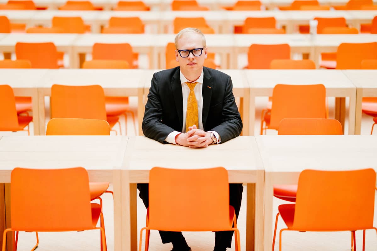 Pääanalyytikko Antti Saari istuu OP:n pääkonttorin ruokalassa, jonka tuolien väri on sama kuin konsernin logossa.