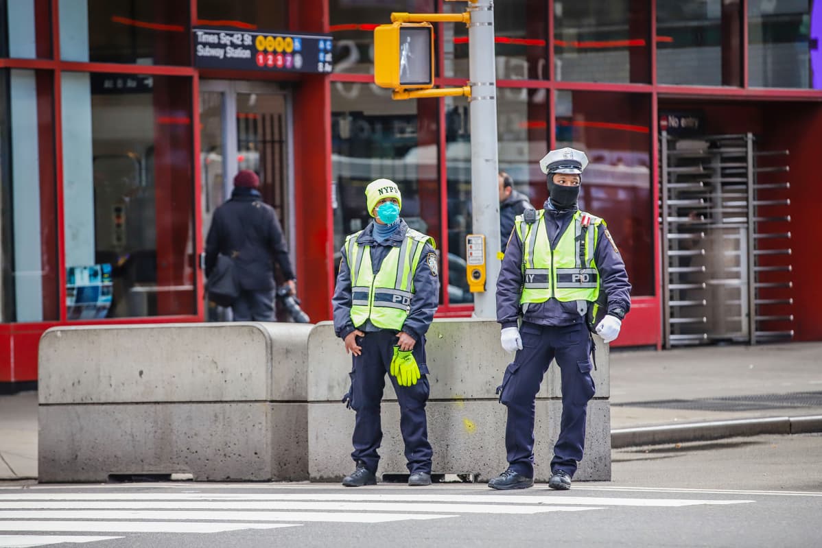 Hengityssuojaimiin pukeutuneet poliisit partioivat Times Squarella.