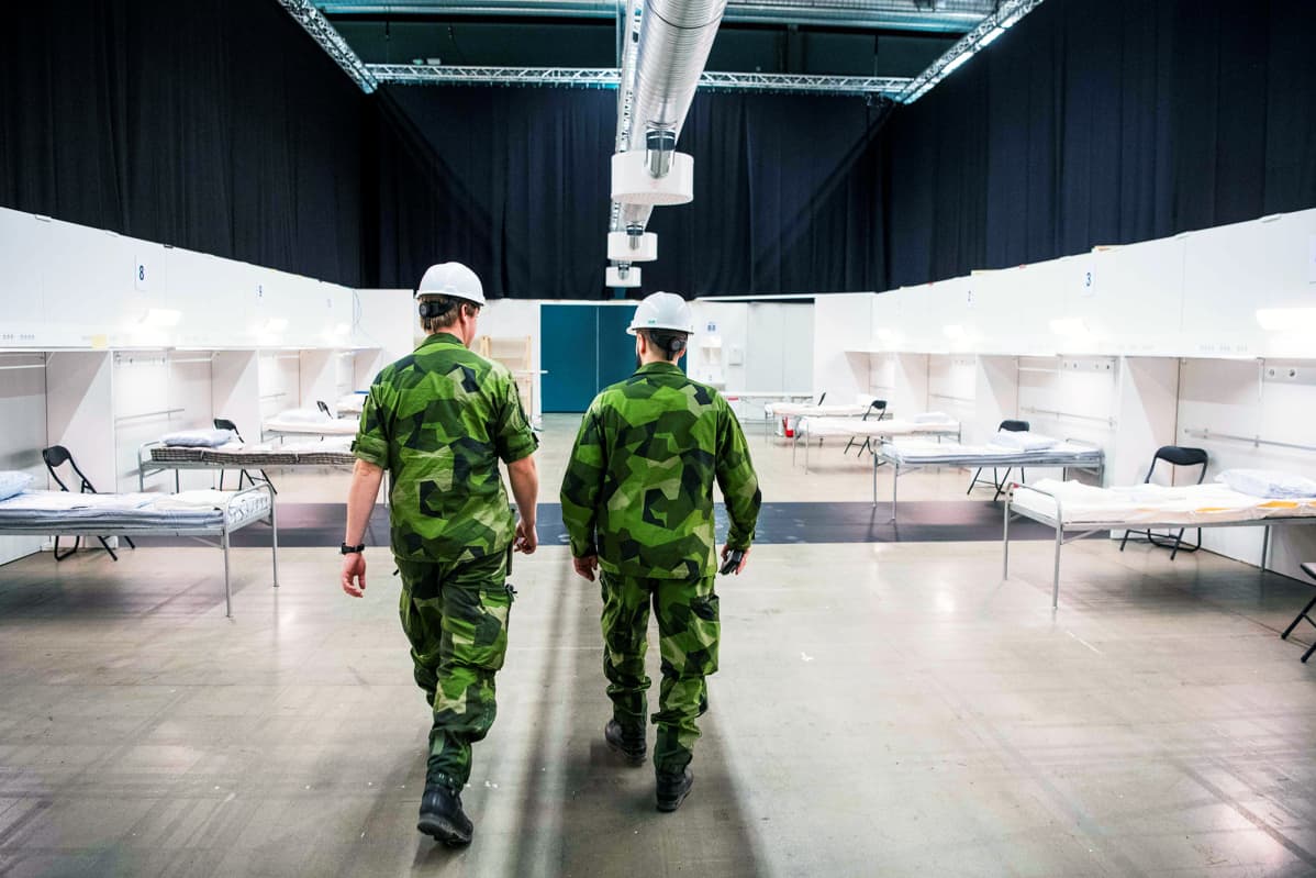 Ruotsin armeijan henkilökuntaa kävelee messukeskukseen rakenteilla olevassa kenttäsairaalassa Tukholmassa.