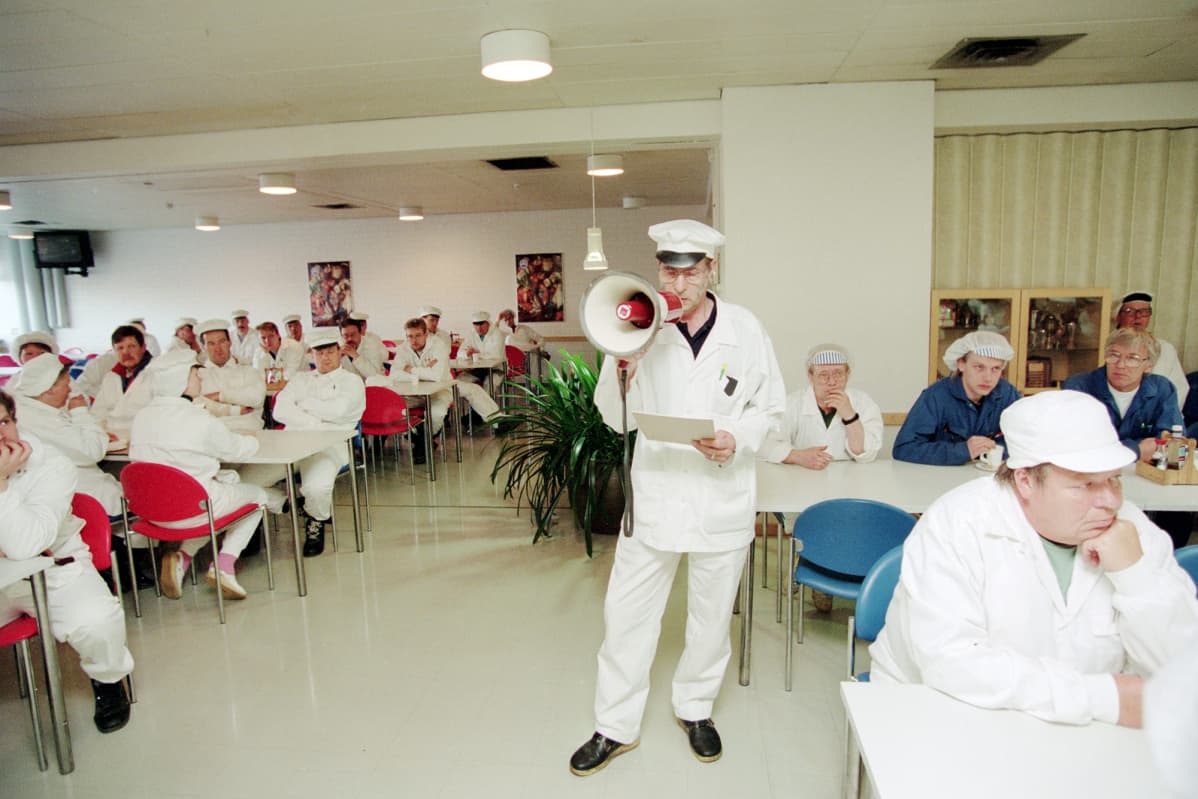 Historiallisessa kuvassa pääluottamusmies Tauno Taskinen puhuu megafoniin HK Ruokatalon irtisanomisinfossa heinäkuussa 1994.
