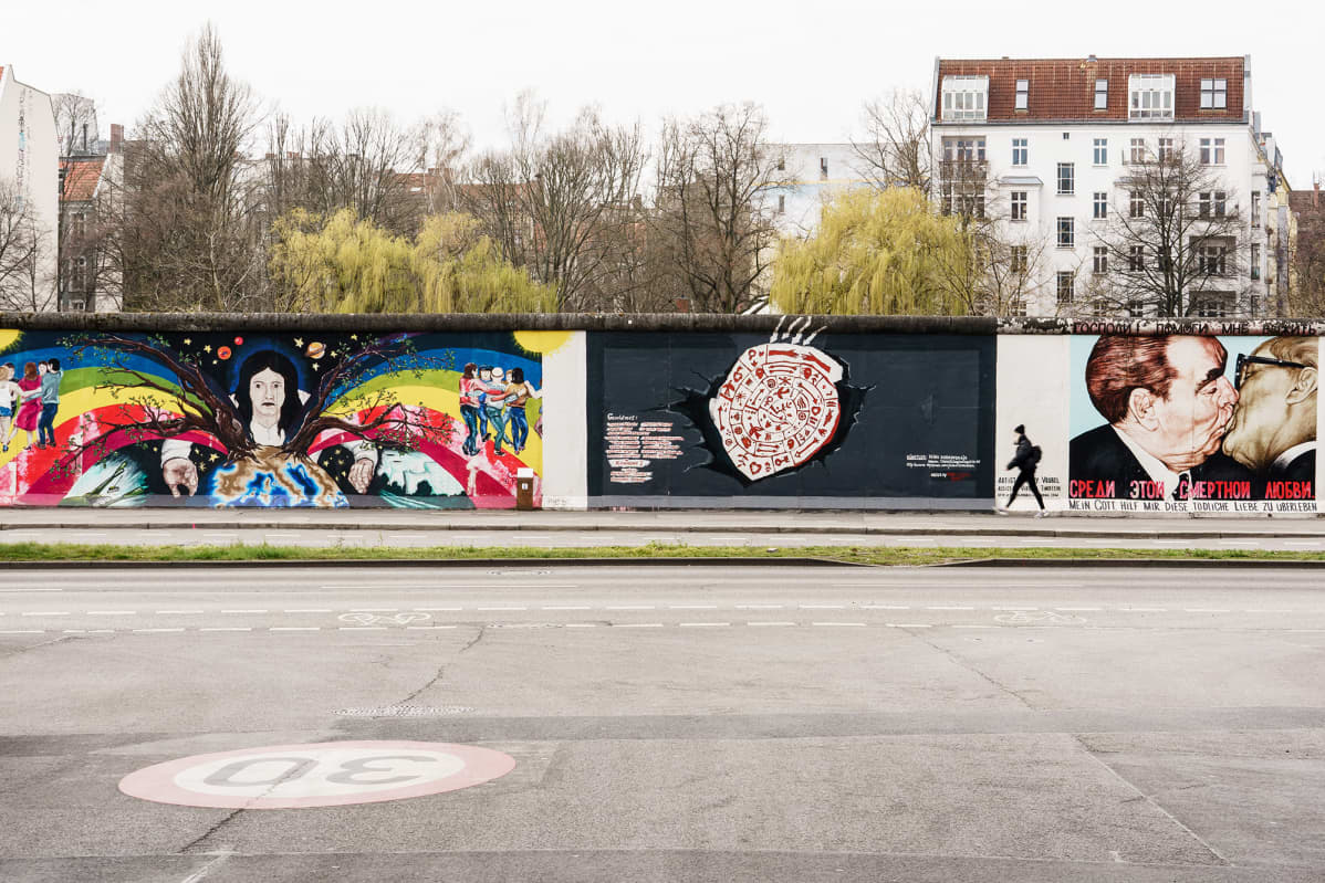 Jalankulkija autiolla jalkakäytävällä Berliinin East Side Galleryn edustalla. Koronakriisi vei turistit.