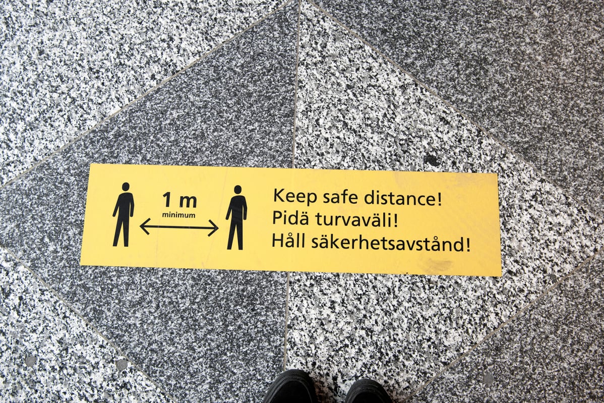 Pidä turvaväli!- tarra lentoaseman lattiassa.