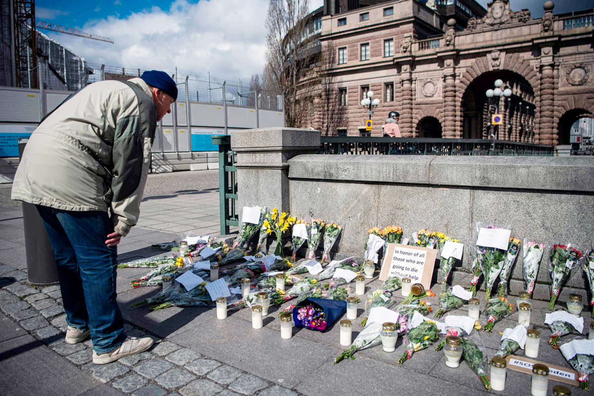 Muistokynttilöitä ja kukkia Tukholman Mynttorget-aukiolla.