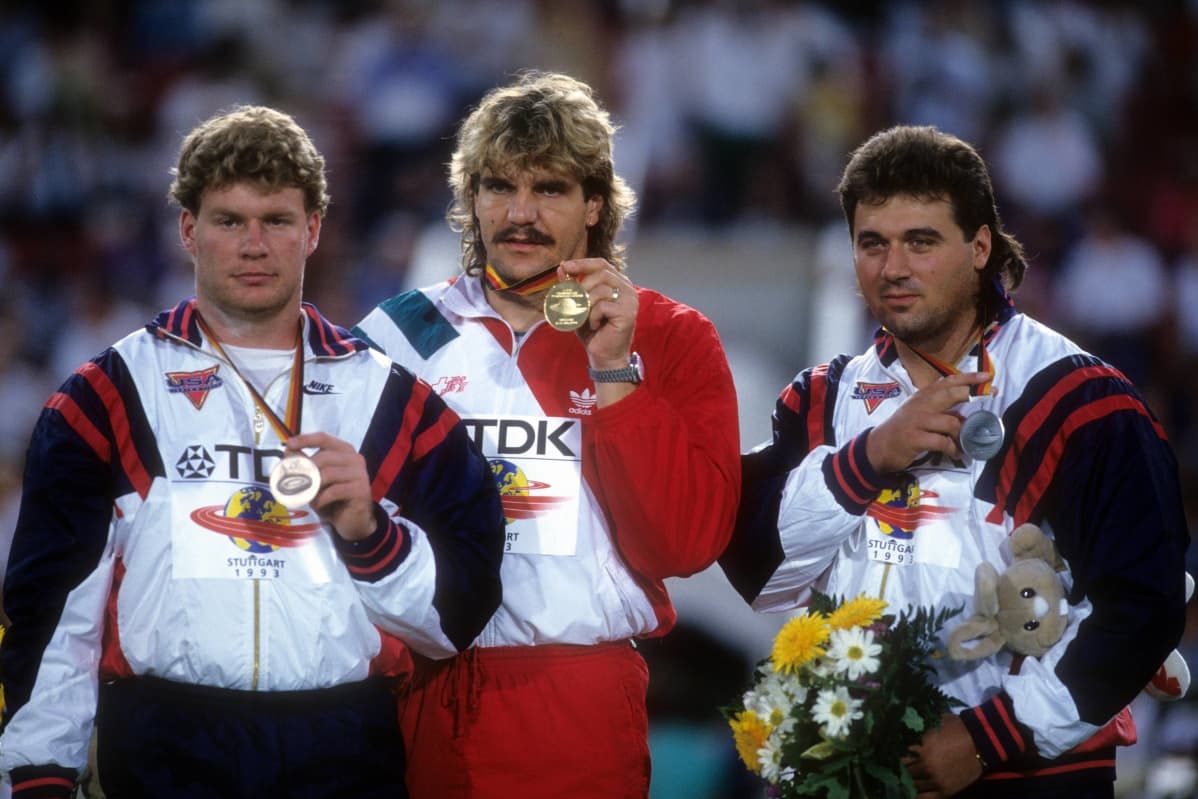 Vuoden 1993 Stuttgartin MM-kisojen mitalikolmikko poseeraamassa parrasvaloissa. Kolmikosta yhdysvaltalaiset Mike Stulce (vas.) ja Randy Barnes (oik.) kärysivät urallaan kahdesti ja saivat elinikäisen kilpailukiellon. Kultamitalisti Werner Günthör (kesk.) ei antanut positiivista dopingnäytettä.