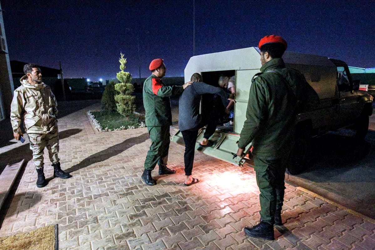 Khalifa Haftarin joukot siirtävät vankeja autoon Libyan Benghazissa.