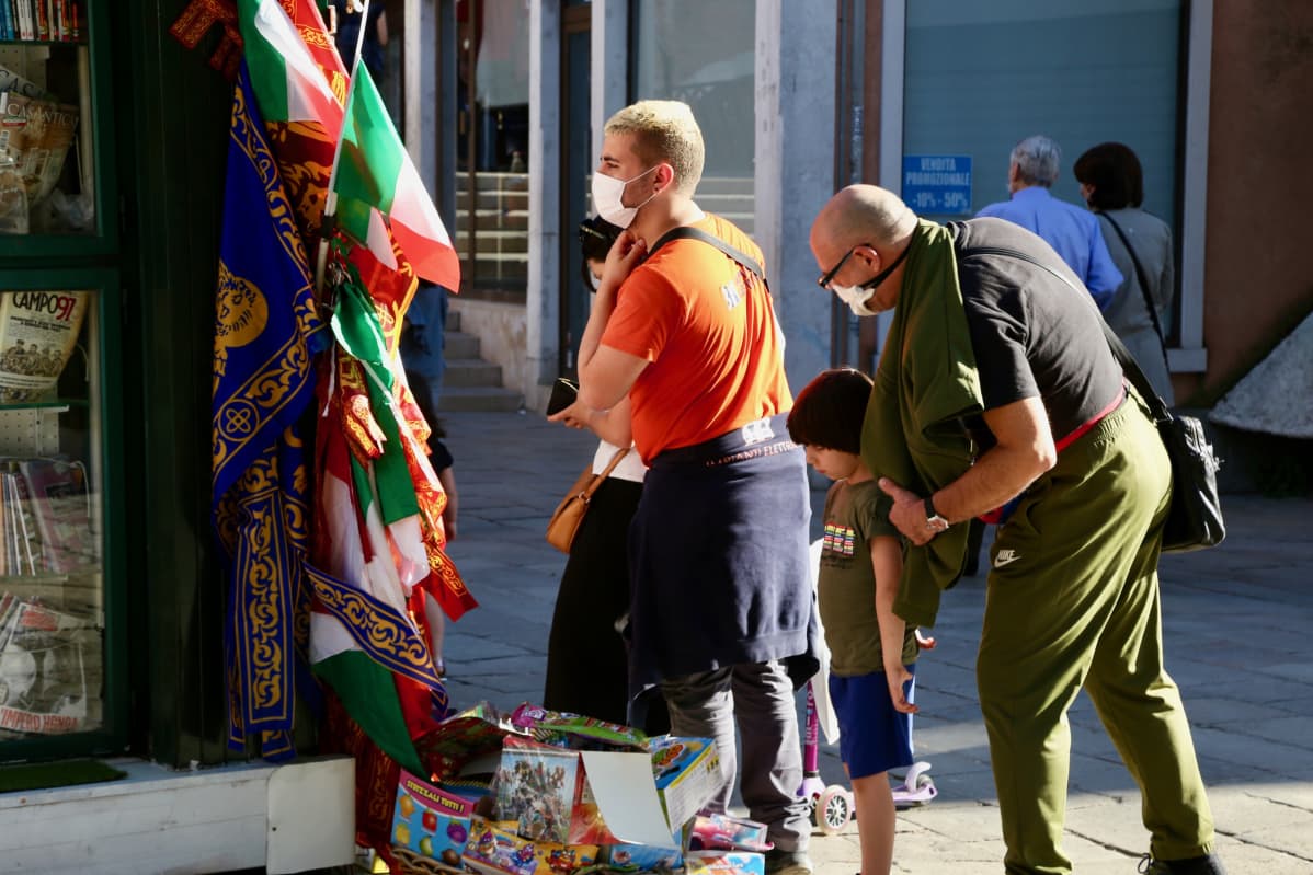 Turisteja venetsiassa suojamaskit kasvoilla.