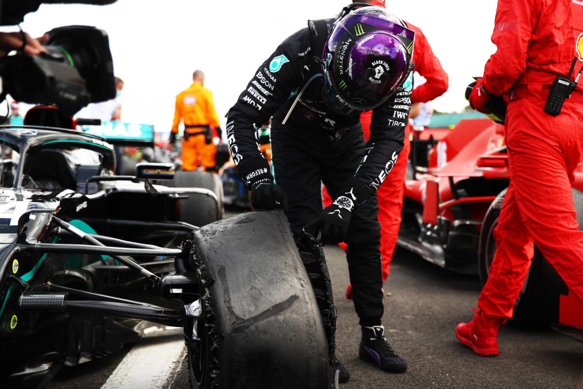 Lewis Hamilton tutkii rikki mennyttä rengastaan Silverstonen kilpailun jälkeen.