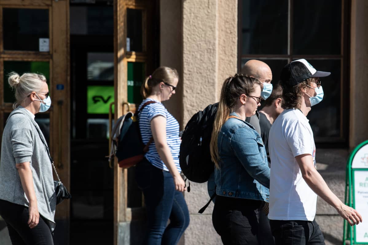 Ihmisiä kasvomaskit päällä Helsingin rautatieasemalla