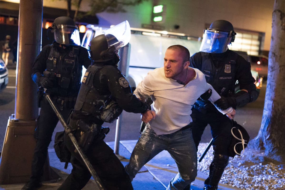 mielenosoittaja poliisin otteessa