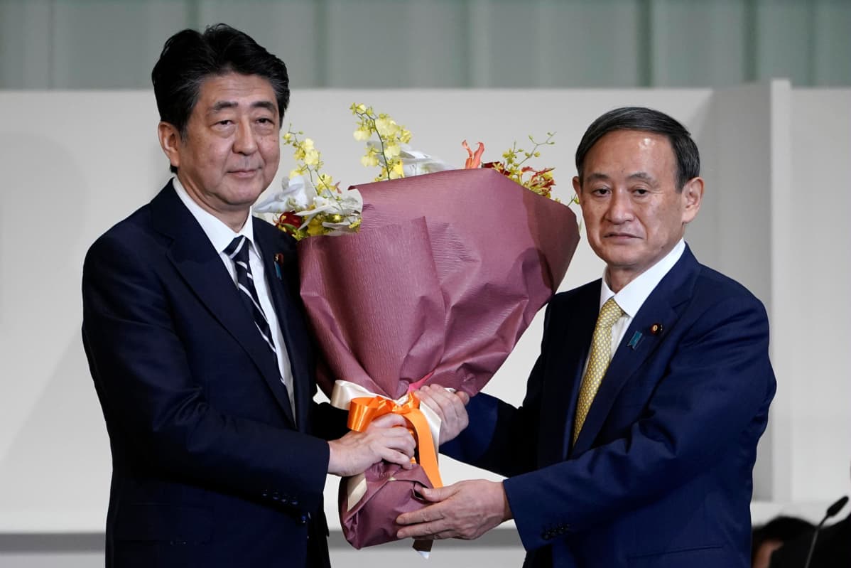 Väistyvä pääministeri Shinzo Abe sai kukkia vastavalitulta Yoshihide Sugalta.