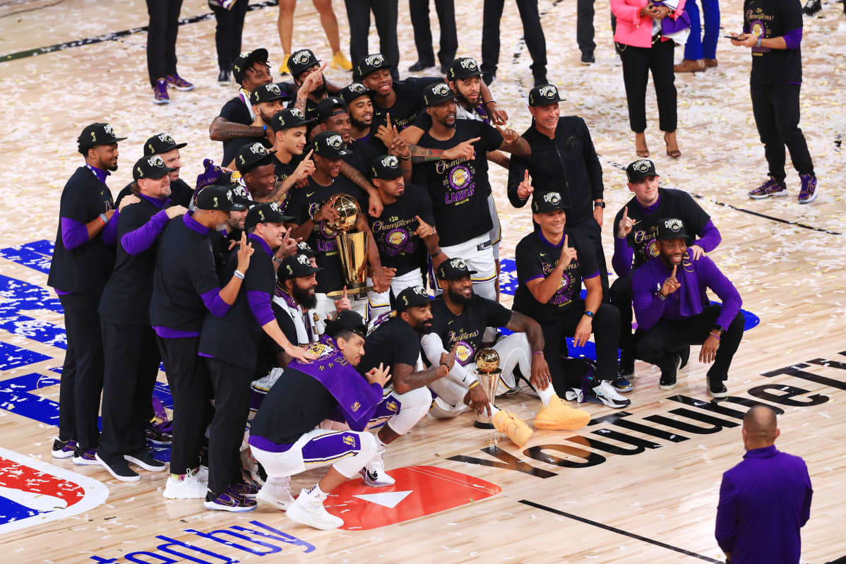 Los Angeles Lakersin pelaajat poseeraavat mestaruuspystin kanssa.