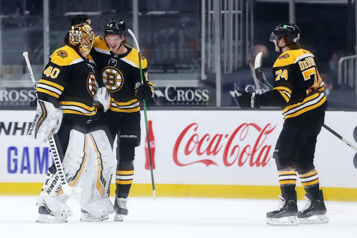 Trent Frederic ja Jake DeBrusk onnittelivat Tuukka Raskia ottelun jälkeen.